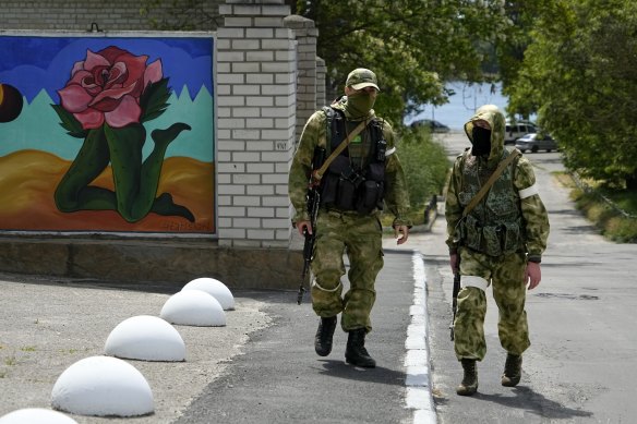 Two Russian soldiers patrol an administrative area at the Khersonvodokanal (water channel) in Kherson in May.