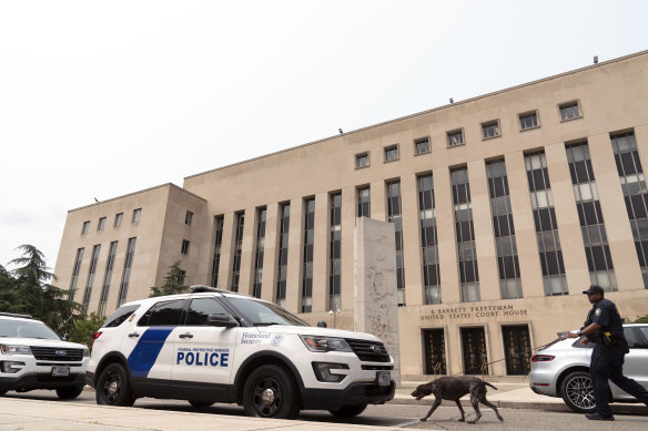A Department of Homeland Security police officer walks with his dog outside federal court in Washington, where Trump has been charged.