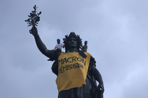 Activists draped the statue on Place de la Republique in Paris with a banner reading “Macron resign” on May 1.