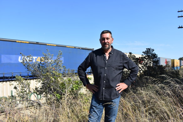 Pete Read and dozens of other residents say a large concrete wall under construction to protect residents at new estate from the  noisy freight line is bouncing the problem over established suburbs.