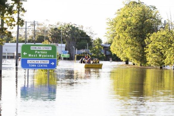 People are taken through the town of Forbes by boat on Thursday. 