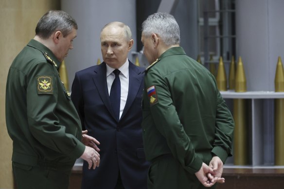 Russian President Vladimir Putin talks with Russian Chief of General Staff General Valery Gerasimov, left, and Russian Defence Minister Sergei Shoigu.