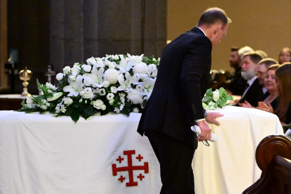 Former prime minister Tony Abbott touches the casket of Kevin Andrews, who served as a minister in his goverment.