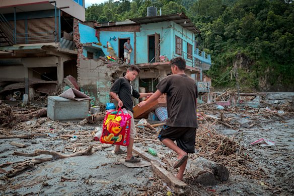 Residents salvage belongings from their destroyed home following flash floods in Devighat, Nepal.