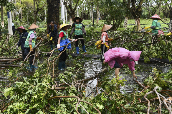 Emergency workers move in to clear fallen branches in Haikou, Hainan province, China, on Saturday, September 7, 2024. 