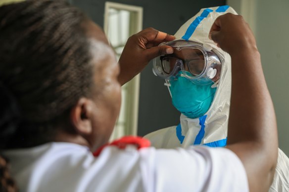 A health worker helps a colleague to put on personal protective equipment at Nairobi Hospital.