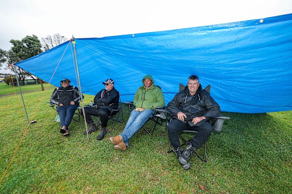 Fans took shelter as they waited in hope for the rain to clear.