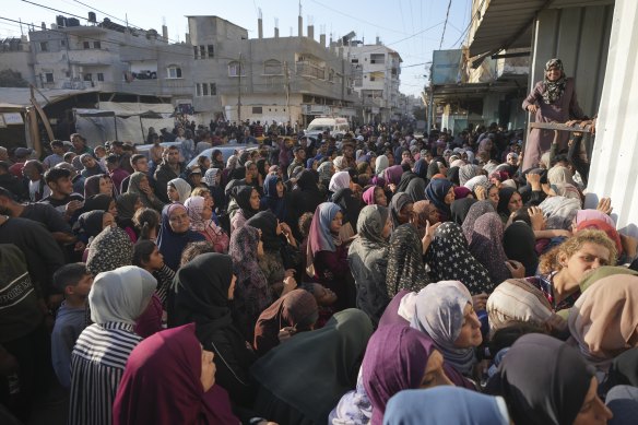A crowd gathers in front of a bakery to get a share of bread in Deir al-Balah, Gaza Strip.