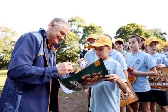 Wallabies head coach Joe Schmidt signs autographs for school children.