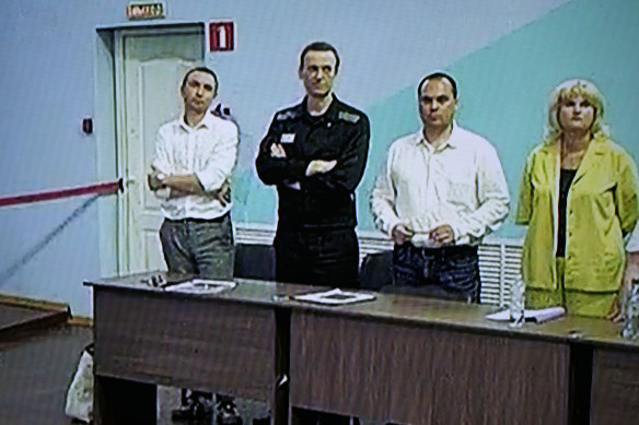 Navalny is seen on a TV screen standing among his lawyers during the sentencing on Friday.