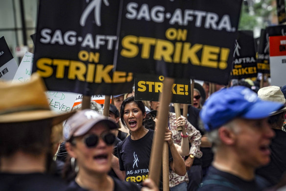 Striking writers and actors chant as they walk a picket line at NBC Universal Studios in New York.