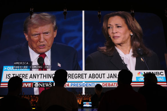 People watch the debate between Donald Trump and Kamala Harris at a club in Las Vegas.