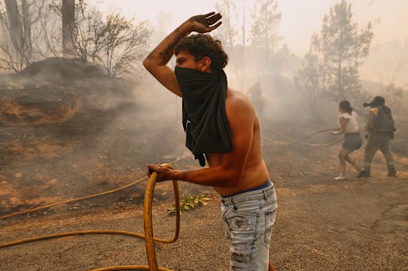 Residentes e voluntários locais tentam colocar o incêndio em Larouce, no noroeste da Espanha.