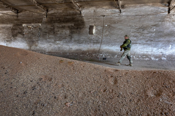 A Ukrainian army officer inspects a grain warehouse shelled by Russian forces.