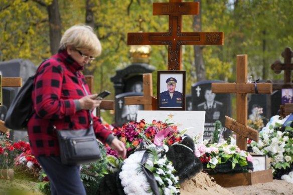 A woman walks past a tomb of Major General of Russian army Vladimir Frolov killed in Ukraine in April 2022 at the Serafimovskoye cemetery in St Petersburg, Russia.