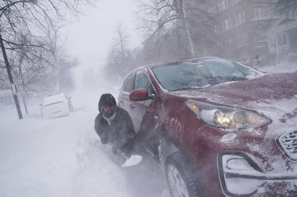 Gamaliel Vega tries to dig out his car in Buffalo, NY.