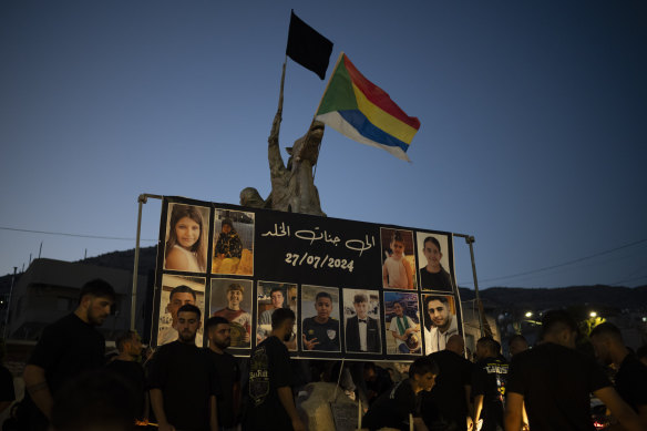 Photos of the children and teens killed in a rocket strike at a soccer field, are displayed at a roundabout as people light candles in their memories, at the village of Majdal Shams.