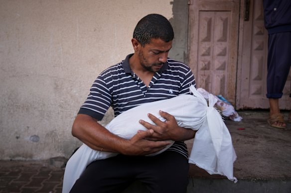Omar Meshmesh carries the body of his three-year-old niece, Aya.