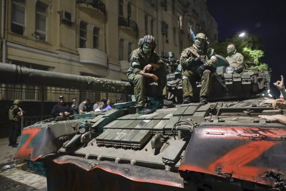 Wagner Group mercenaries sit atop a tank before leaving Rostov-on-Don on Saturday.