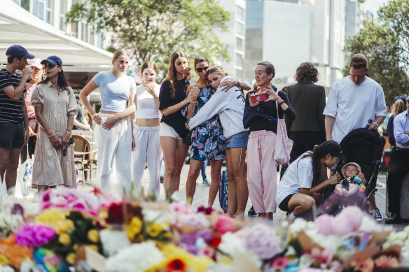People are emotional as they pay tribute with flowers to the victims at Bondi Junction on Sunday.