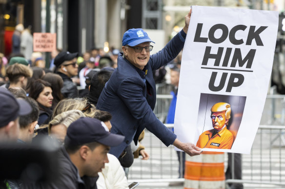 Bir protestocu, New York'taki Trump Tower'ın dışında bir pankart tutuyor.