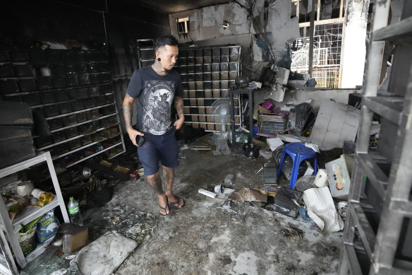 The owner of a pet shop surveys damage after a fire at Chatuchak Weekend Market, one of the most famous markets in Bangkok, Thailand.