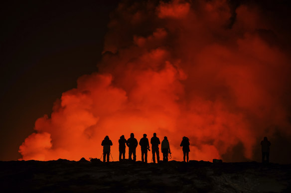 People watching the volcano north of Grindavík, Iceland. The eruption of the Sylingarfell volcano began at 6am local time on Thursday, soon after an intense burst of seismic activity.