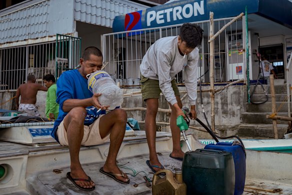 يشترى الصيادون في الفلبين وقودًا في محطة بجوار النهر قبل يوم من ارتفاع كبير في أسعار الوقود الناتج عن الحرب الأمريكية الإسرائيلية على إيران. 