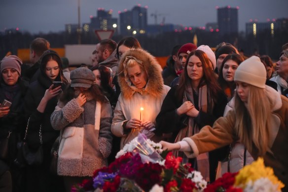 People lay flowers and light candles near Crocus City Hall at the weekend.