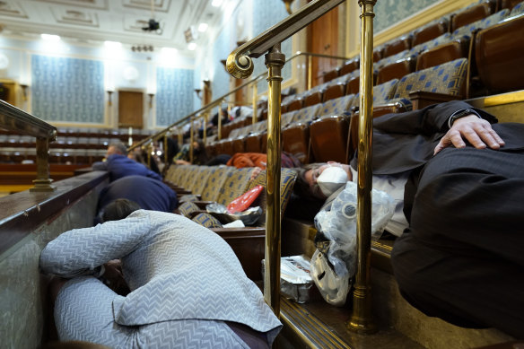 People shelter in the gallery as protesters try to break into the House Chamber on January 6.