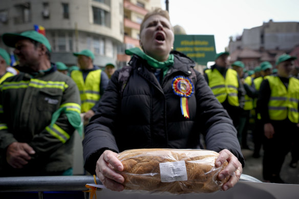 A woman holds a loaf of bread during a farmers’ protest in front of the Representative Office of the European Commission in April.