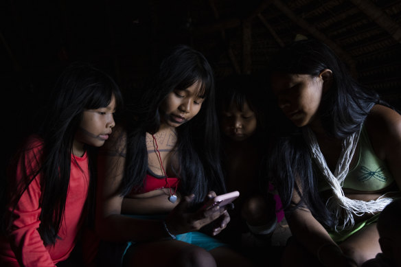 Marubo indigenous people use their phones in Manakieaway.