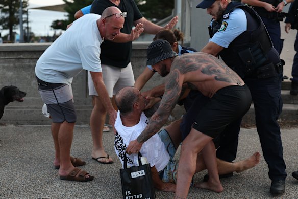 Transeuntes auxiliam um homem em Bondi Beach na noite de domingo.