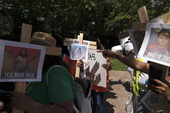 Protesters in Houston 
carry crosses with photos of victims of the Robb Elementary School shooting in Uvalde, Texas.