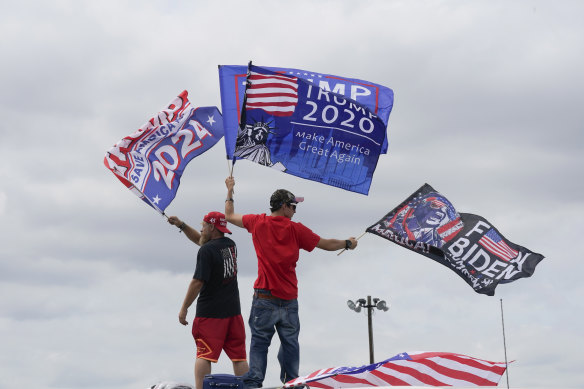 Eski Başkan Donald Trump'ın destekçileri, Pensilvanya'nın Wilkes-Barre kentinde düzenlenen mitingden önce bayrak sallıyor.