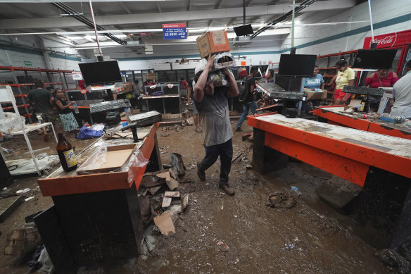 People loot a supermarket after the storm in Acapulco.