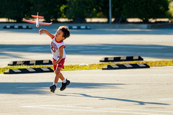 A boy throws a glider in a car park, at the Cabrillo Way Marina in San Pedro neighborhood of Los Angeles.