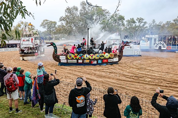 Participants and crowds enjoy the fun of an unusally wet day at annual regatta in the dry river bed.