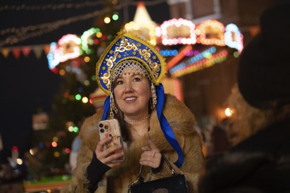 A woman in Russian kokoshnik takes a photo at a Christmas Market set up in Red Square before its closure for celebrations on New Year’s Eve.