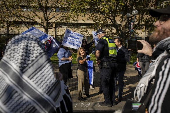 Police speak to Jewish rally members yelling at the pro-Palestine camp.