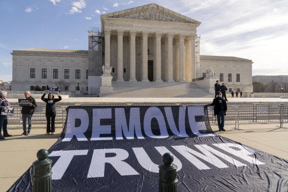 Demonstrators hold a banner outside of the US Supreme Court where the hearing was taking place.