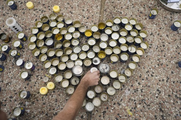 Un homme place une bougie dans un mémorial pour les otages décédés Shiri Bibas, ses deux enfants, Ariel et Kfir et Oded Lifshitz.
