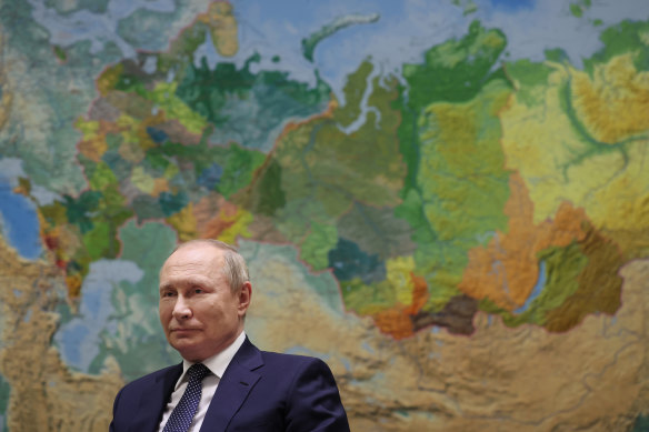 Президент России Владимир Путин стоит перед картой России и региона, куда бегут его граждане. 