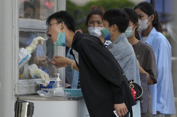 Residents line up to get their routine COVID-19 throat swabs at a coronavirus testing site outside a residential complex in Beijing.