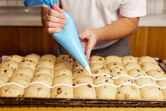 Hot cross buns being prepared at Woolworths.