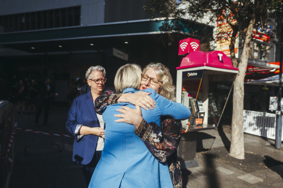 (L-R) Acting NSW Premier Penny Sharpe stands by Waverley mayor Paula Masselos as she hugs NSW Police Minister Yasmin Catley after laying flowers at the scene.