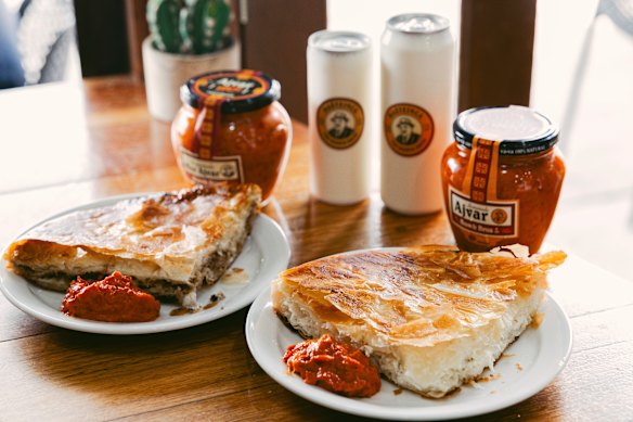  A slice of meat burek and cheese burek, served with buttermilk drink and ajvar.