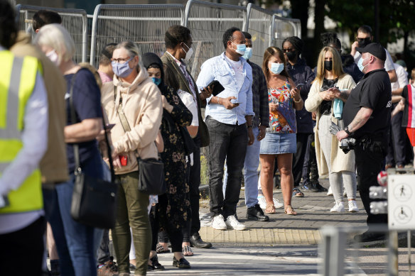 People queue at a walk-in COVID-19 testing centre in Bolton, in northern England. 