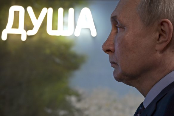 Russian President Vladimir Putin visits an exhibition at the Zotov Cultural Center in Moscow on the day of the strikes. The word in lights spells “soul”.