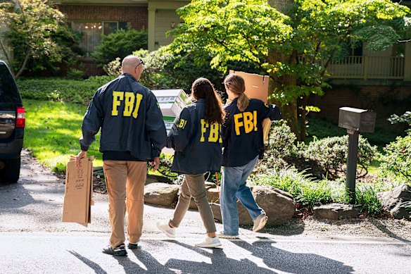FBI agents carry empty boxes to former national security adviser John Bolton’s house.